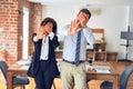 Two middle age business workers standing working together in a meeting at the office covering eyes with hands and doing stop Royalty Free Stock Photo