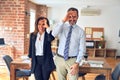 Two middle age business workers standing working together in a meeting at the office doing ok gesture with hand smiling, eye Royalty Free Stock Photo