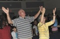 Two middle aged peoople worshiping in a church