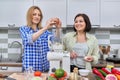 Two middle aged women cooking together at home in the kitchen Royalty Free Stock Photo