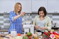 Two middle aged women cooking together at home in the kitchen Royalty Free Stock Photo