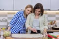 Two middle aged women cooking together at home in kitchen Royalty Free Stock Photo