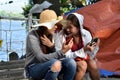 Two 2 middle aged women having fun sharing thoughts and stories holding smart phone.