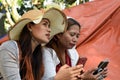 Two 2 middle aged women having fun sharing thoughts and stories holding smart phone.