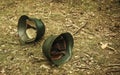 Two military helmets are lying on the ground in the forest.End of war