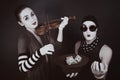 Two mimes playing a violin for the money Royalty Free Stock Photo
