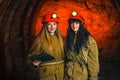 Two miners in the mine. Girls in red helmets and lanterns in a coal mine. Coal mine work plan. Royalty Free Stock Photo