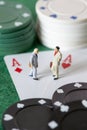 Two miniature businessman standing on two aces