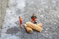 Two miniature garbage men cleaning and sweeping smoked cigarettes on the street Royalty Free Stock Photo