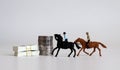 Two miniature riders riding and money. The concept of online sports betting.