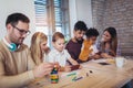 Two mixed race couple play educational games with their children