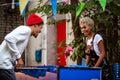 Two mixed race female and male friends play table football outdoor, entertain themselves. Positive stylish mulatto