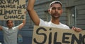 Two mixed race men on a protest march holding placards raising hands and shouting