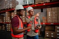 Two mixed race workers holding digital tablet discussing location of parcels in packaging factory Royalty Free Stock Photo