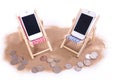 Two mobile phones in toy beach chairs