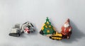 Two models of toy excavators, souvenir snowman, figurine of Santa Claus, Christmas tree made of wood lie on white snow Royalty Free Stock Photo