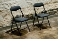 Two modern black chairs in a strong rock prison cell Royalty Free Stock Photo