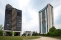 two modern buildings, each with their own unique identity and style, standing side by side