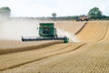 Two modern combine harvester cutting crops corn wheat barley working golden field Royalty Free Stock Photo