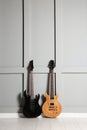 Two modern electric guitars near grey wall Royalty Free Stock Photo