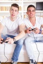 Two modern guys playing computer game holding controllers Royalty Free Stock Photo