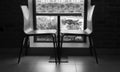 Two modern style chairs near the cute little table near the wind Royalty Free Stock Photo