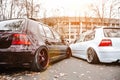 Two modified low cars in brown and light blue color. Stance custom cars with a forged polished wheels parked on a street at sunny