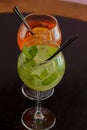 Two mojito alcohol cocktails with plastic straw, tropical beverage with ice, mint and lime, copy space. Royalty Free Stock Photo