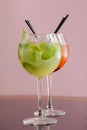 Two mojito alcohol cocktails with plastic straw, tropical beverage with ice, mint and lime on pink background copy space Royalty Free Stock Photo