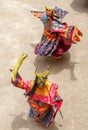 Two monks in a bull deity masks with ritual dagger phurpa perform religious Cham dance of Tibetan Vajrayana Buddhism