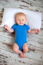 A two-month-old baby lies on the floor