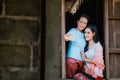 Mother and daughter in a traditional Thai dress are taking pictures of themselves with a mobile phone from a wooden window Royalty Free Stock Photo