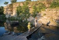 Two - mother and son, walk along the bridge across the mountain river against the backdrop of natural landscape Royalty Free Stock Photo