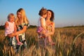 Two mothers with children on wheaten field Royalty Free Stock Photo