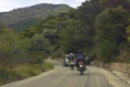 Two motorbikes following car before turning road in mountain area. Royalty Free Stock Photo