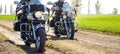 Two Motorcycle Drivers Riding Custom Chopper Bikes on an Autumn Dirt Road in the Green Field. Adventure Concept. Royalty Free Stock Photo