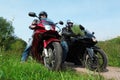 Two motorcyclists standing on country road