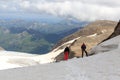 Two mountaineers standing on glacier and looking towards Grossglockner High Alpine Road and mountain panorama in Glockner Group, Royalty Free Stock Photo