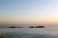 Two mountains stand out above the mist. Sunset. CÃÂ­es islands, Estuary of Vigo, Spain