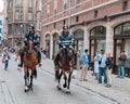 Two mounted policemen patrol the street in center