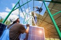 Two mounters installing solar batteries on metallic construction. Royalty Free Stock Photo