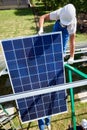 Two mounters installing solar panels on green metallic carcass. Royalty Free Stock Photo