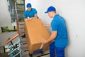 Two Movers With Box On Staircase Royalty Free Stock Photo