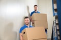 Two Movers Carrying Cardboard Boxes On Staircase Royalty Free Stock Photo