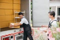 Two movers from a relocation company unload boxes exhibiting teamwork and Royalty Free Stock Photo