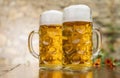 Two mugs of beer with foam stand on the table Royalty Free Stock Photo