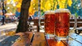 Two mugs of beer resting on a wooden table against a scenic autumn backdrop, Ai Generated Royalty Free Stock Photo