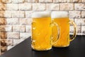 Two mugs of light beer on the table Royalty Free Stock Photo