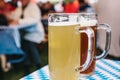 Two mugs with a light and dark beer stand on the table. In the background, blurred people. Celebrating the traditional Royalty Free Stock Photo