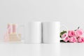 Two mugs mockup with a bouquet of pink roses and silk ribbons on a white table